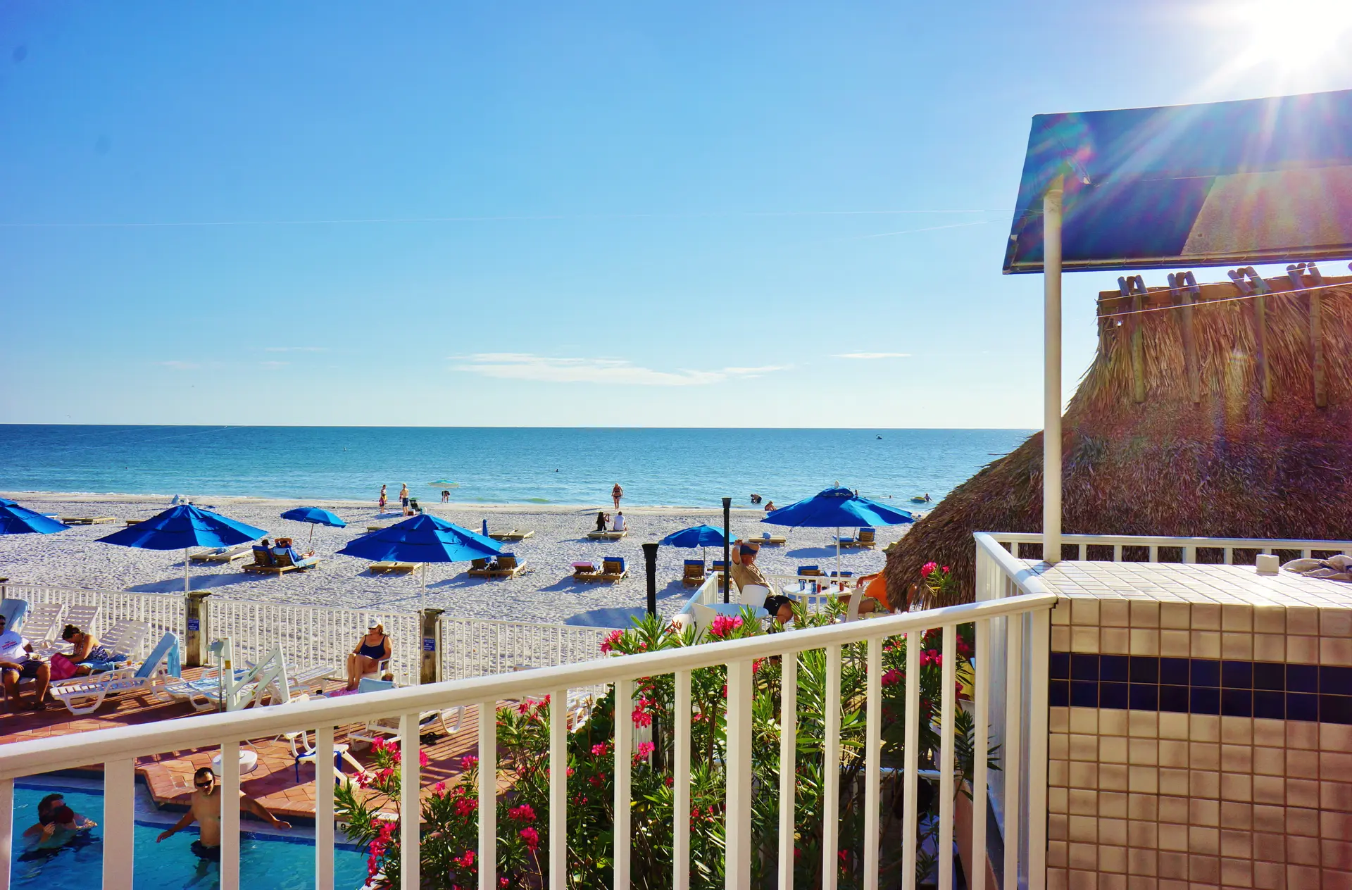 Indian Rocks Beach shoreline with white sand, blue umbrellas and Gulf water